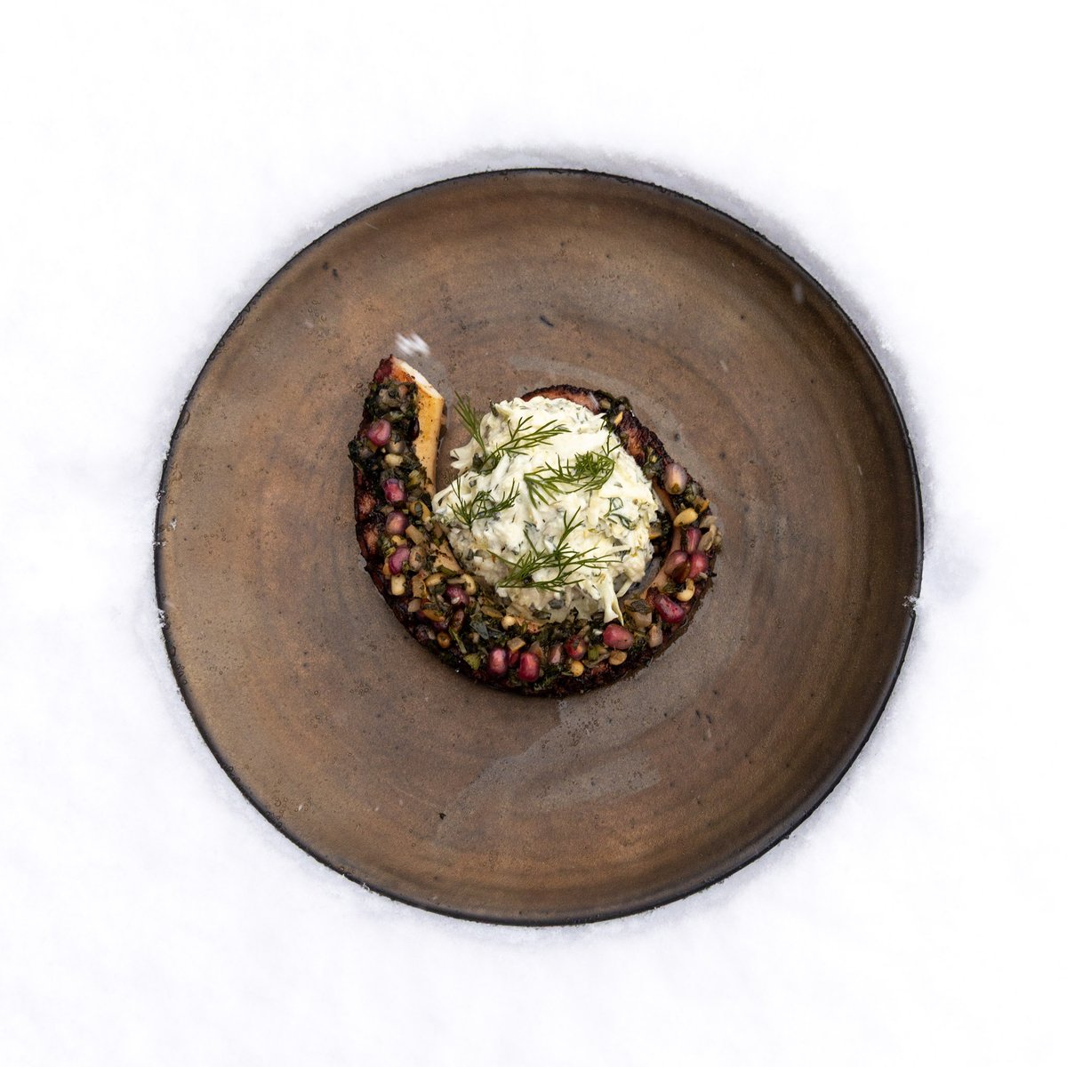 Plat gastronomique sur assiette artisanale dans la neige - IMA Val d'Isère