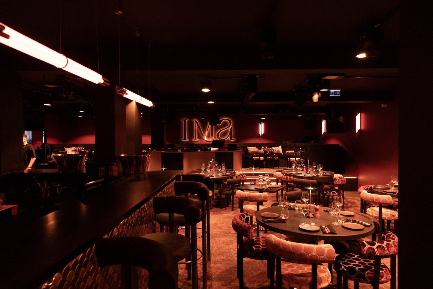 Intérieur du restaurant IMA Val d'Isère - Tables dressées et néon IMA